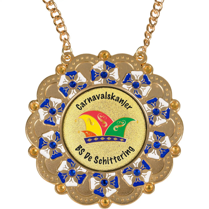 Medaille Baltasar goudkleurig met kunststof diamandjes en blauw-wit ingekleurde accenten. Voorzien van logo van carnavalssteek met tekst naar keuze.